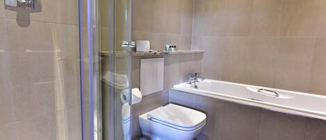 Une salle de bain moderne avec une douche à parois de verre, des toilettes et une baignoire.