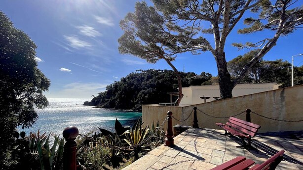 A coastal walkway with benches, a chain-link fence, and a view of the sea. - 2-room apartment with air conditioning in Cavalaire-sur-Mer (Cavalaire-sur-Mer)