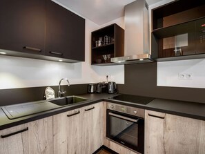A modern kitchen with a built-in oven, a sink, and a stove. - Charming T2 apartment in Les Saisies, near slopes (Les Saisies)