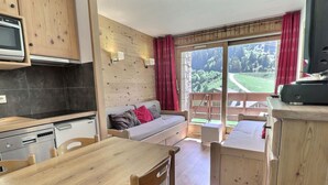 A cozy, compact living space with a kitchenette, a dining area, and a sofa. - Renovated ski-in studio, 4 guests, Méribel (Méribel)