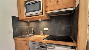 A compact kitchen with a built-in oven, a dishwasher, and a stovetop. - Renovated ski-in studio, 4 guests, Méribel (Méribel)