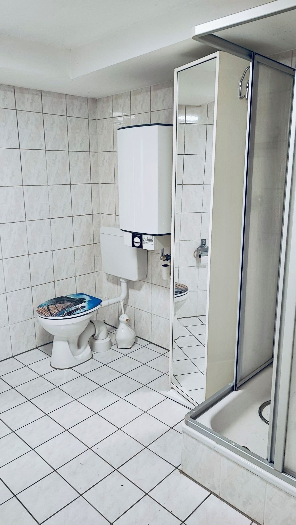 Een badkamer met toilet, bidet en een douchecabine.