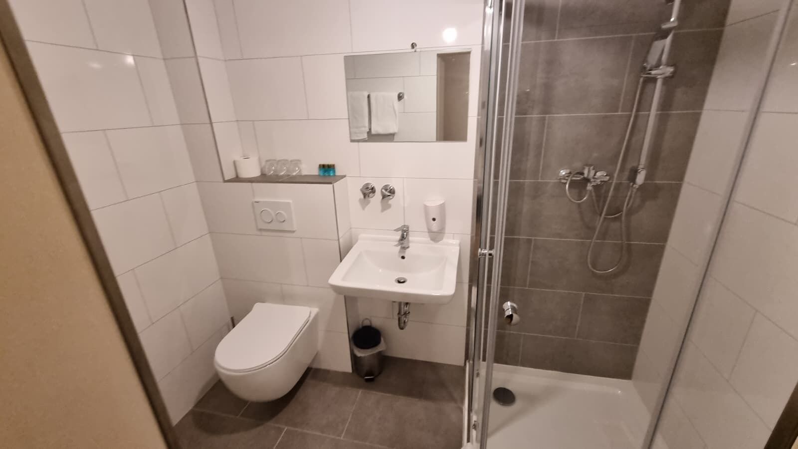 Ein kleines Badezimmer mit Toilette, Waschbecken und einer Duschkabine.