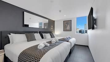 Familie-studiosuite, byutsikt | Sengetøy av topp kvalitet, minibar og safe på rommet