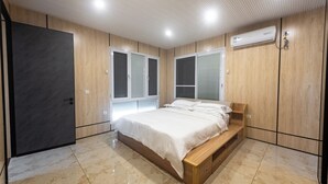 A bedroom with a bed, wooden wardrobe, and a window with blinds. - Beach Front 2 Bed Condon C1.1 with Sea View and Private Pool !! (Simpson Bay)