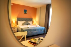 Ein Hotelzimmer mit einem Bett, Nachttischen und einem kleinen Tisch mit Büchern.