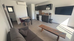 Eine moderne Wohnung mit Wohnbereich, Küchenzeile und Essbereich.