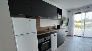 Eine moderne Küche mit Kühlschrank, Backofen, Geschirrspüler und Mikrowelle.