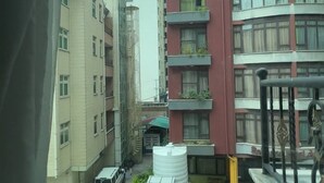 A view of a residential building with multiple floors, balconies, and a parking area with several vehicles. - The Sheger Addis Blue Luxury Hotel (Addis Ababa)