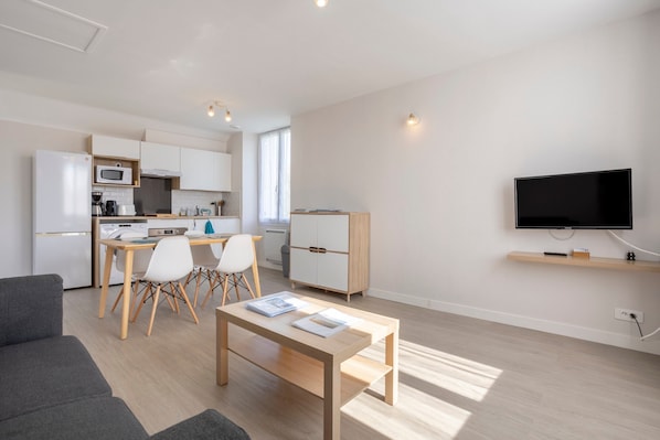 Un appartement moderne comprenant une cuisine, un coin repas et un salon.