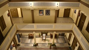 Eine geräumige Lobby mit hoher Decke, einer zentralen Sitzgruppe und mehreren Türen.