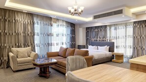 A modern hotel room with a large bed, a sofa, a dining table, and a chandelier. - VESTA - New Cairo Residennce (New Cairo)