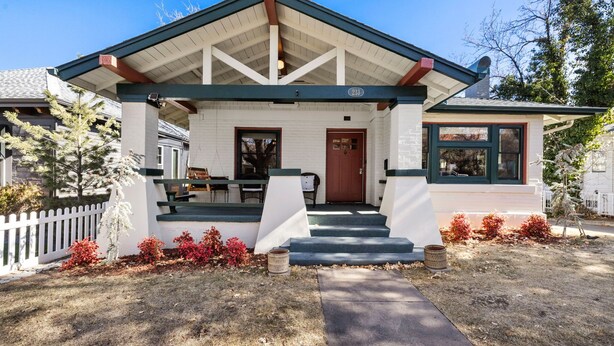 A single-story building with a covered porch, a front door, and a small window.