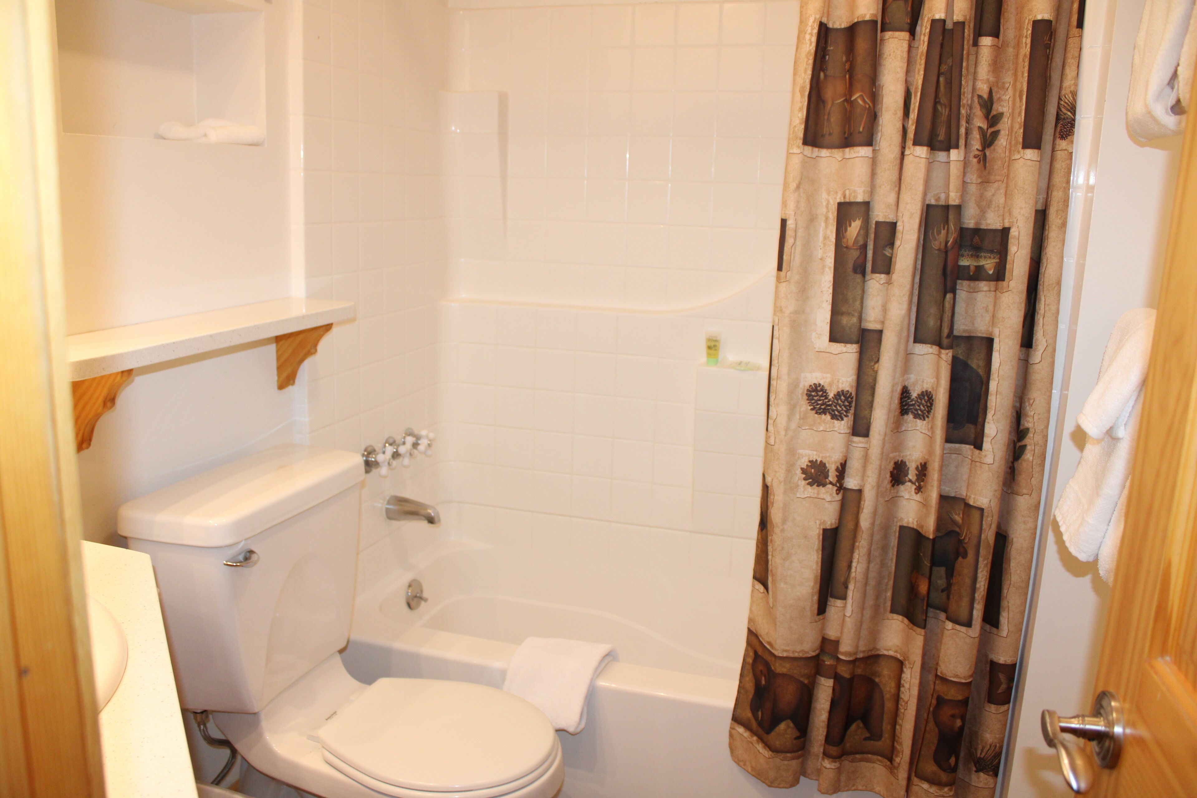 A bathroom with a toilet, a bathtub, and a shower curtain.