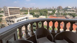 A balcony with wicker furniture and a city view. - VESTA - Mohandessin (Giza)