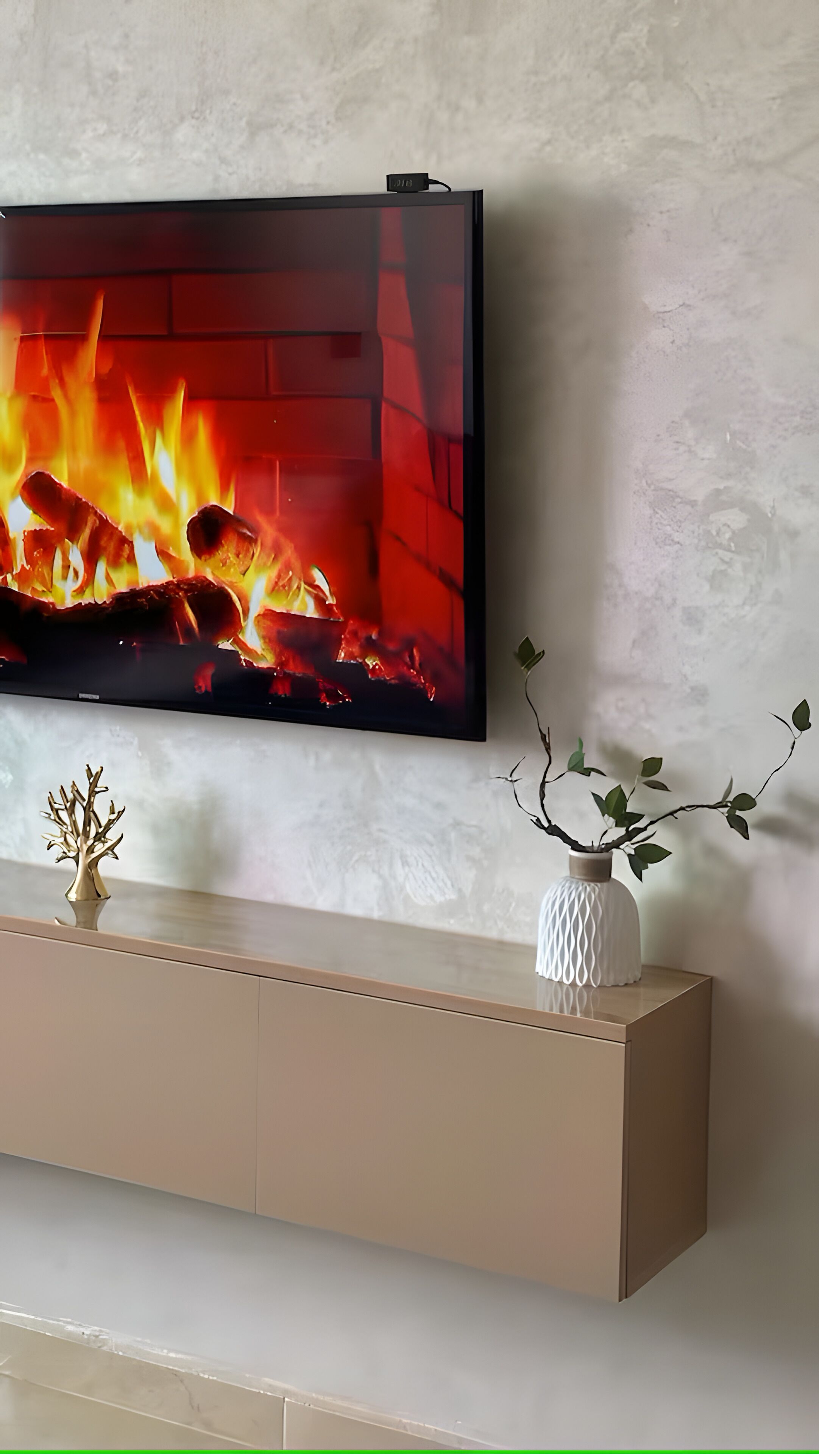 A flat-screen TV mounted on a wall above a beige console with decorative items.