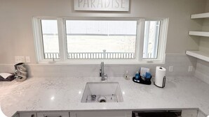 A kitchen with a large window, a sink, and a 'PARADISE' sign above it. - 2 Bedroom Riverfront House on the New River Trail (Allisonia)
