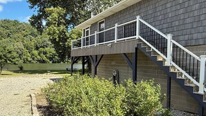A building with a covered outdoor area, a staircase, and a view of a lake. - 2 Bedroom Riverfront House on the New River Trail (Allisonia)