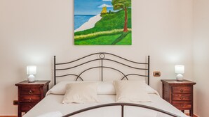 Camera da letto con un letto, due comodini, un quadro e un condizionatore d'aria.