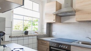 Una cocina moderna con ventana, estufa y lavamanos.