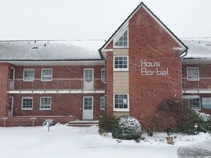 Un bâtiment en briques de deux étages, avec une enseigne indiquant « Haus Bärbel » sur la façade.