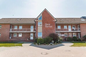 Un bâtiment à deux étages, construit en briques, avec une entrée centrale et une enseigne portant l’inscription « Haus Bärbel ».