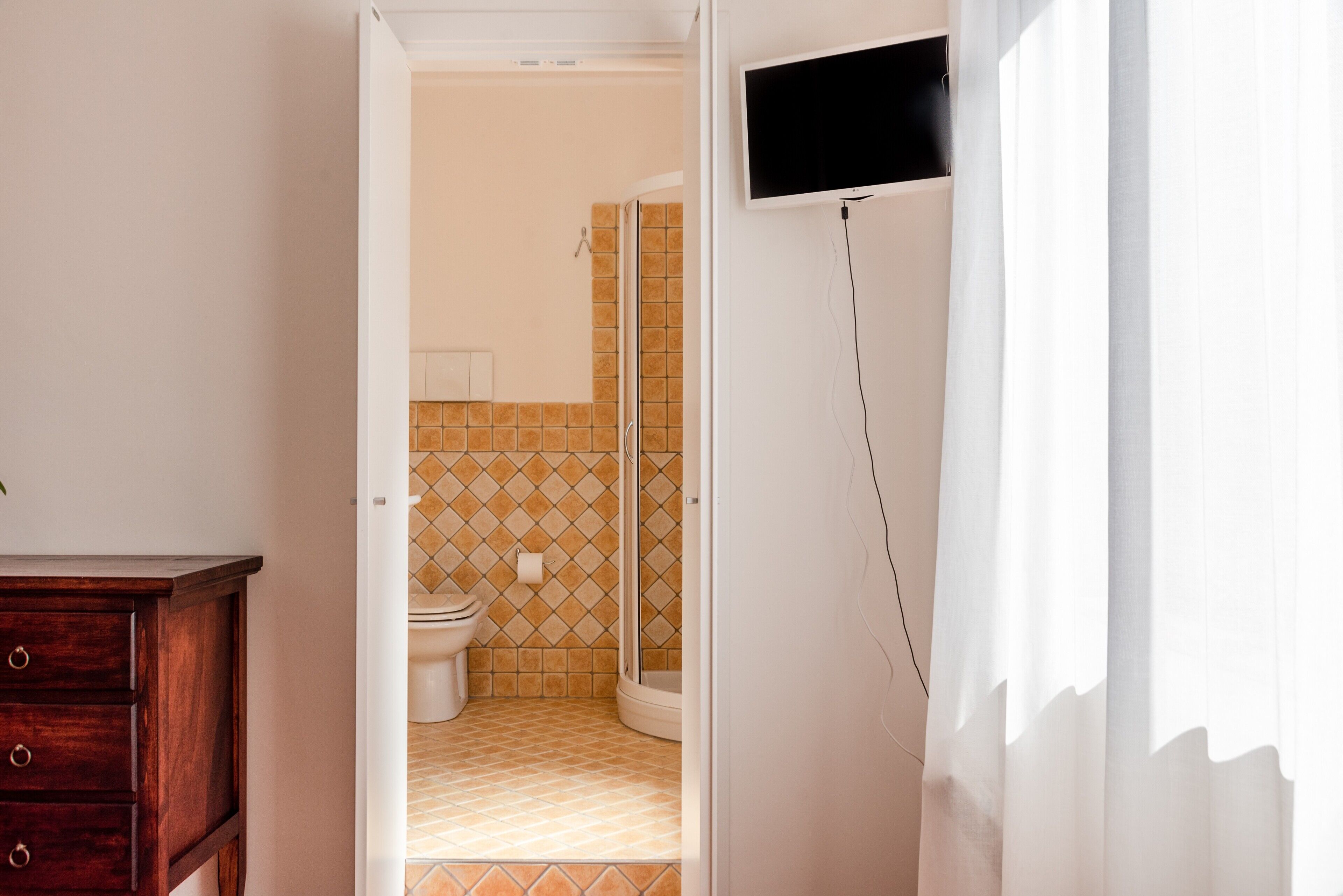Ein Badezimmer mit Toilette, Dusche und einem Holzkabinent.