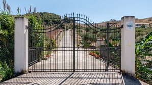 A gated entrance with a metal gate, a concrete pathway, and potted plants. - Room 'Monte Suso' with sea view, shared terrace and air conditioning (Montallegro)