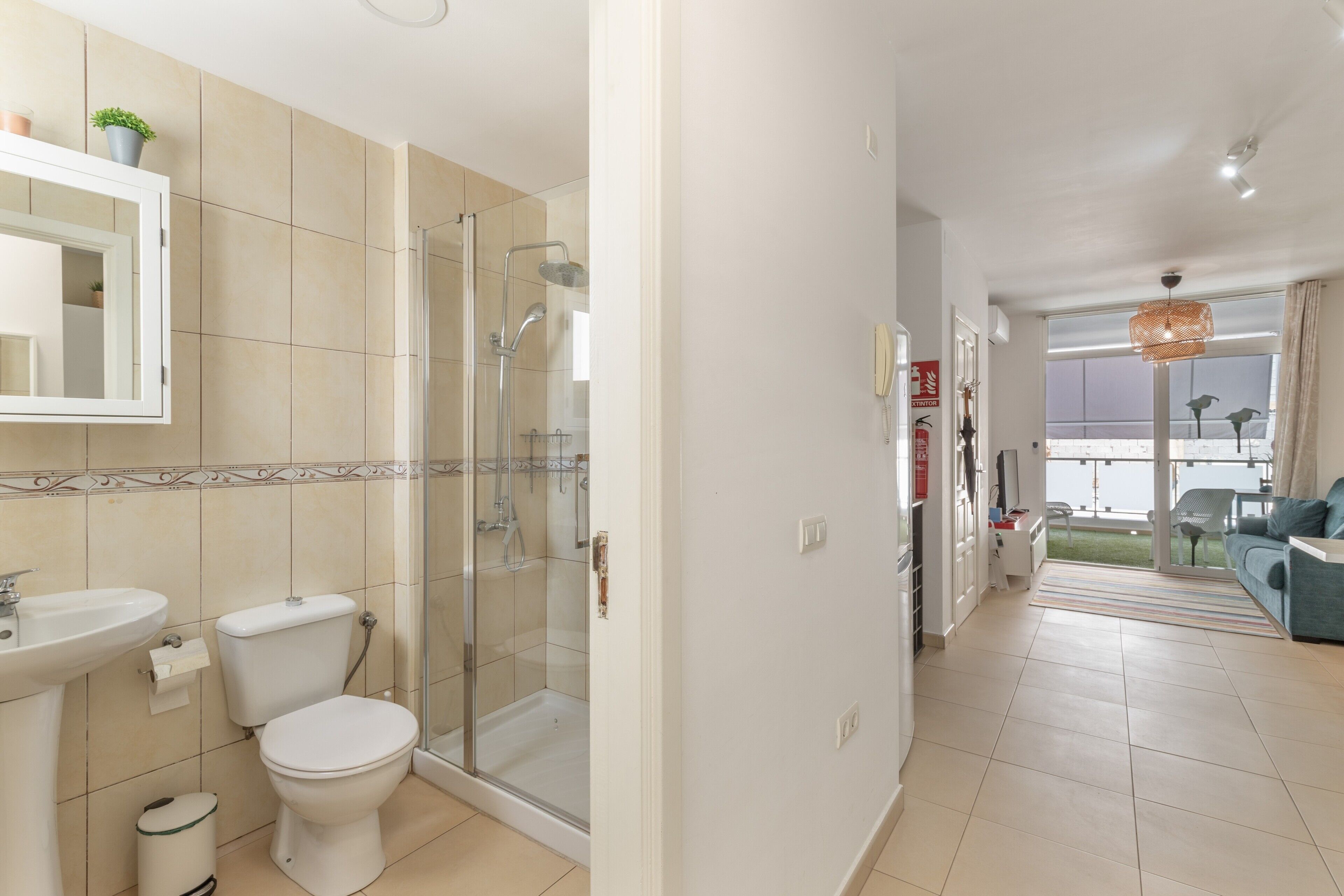 Une salle de bain équipée d’une douche, de toilettes, d’un lavabo et d’un miroir.