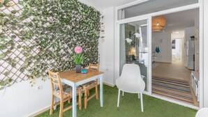 A dining area with a wooden table, chairs, and a decorative wall with greenery.