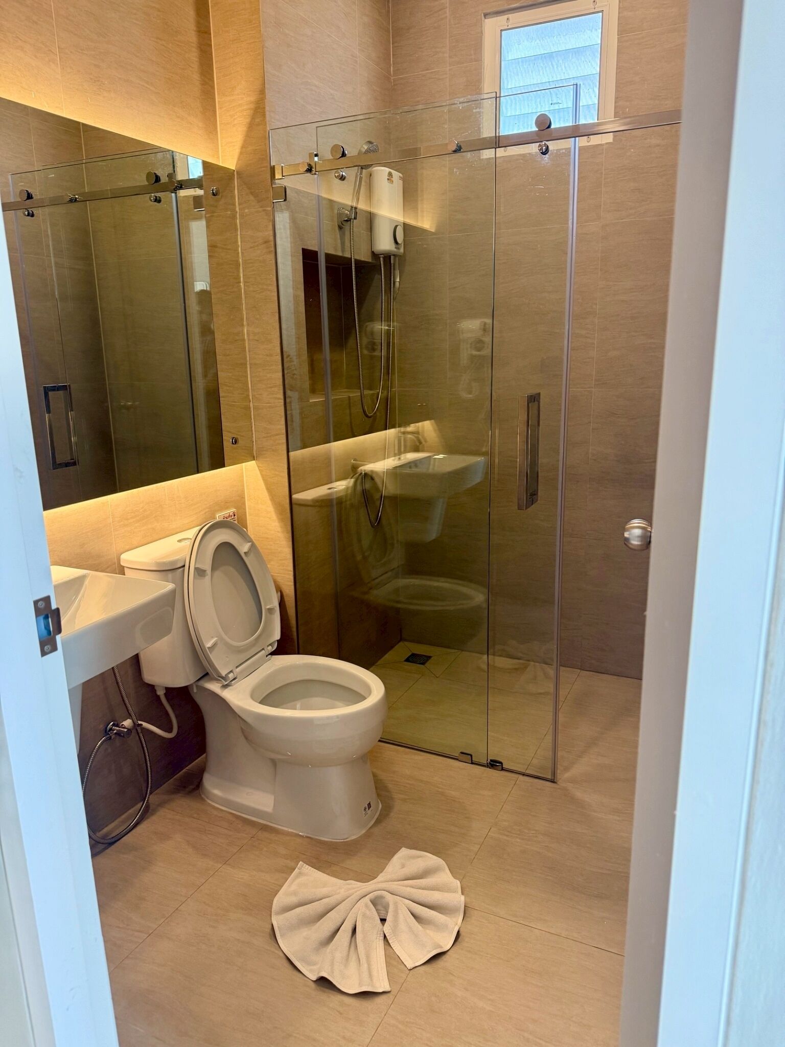 Un baño moderno con ducha de vidrio, inodoro y lavamanos.