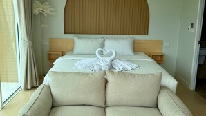 Un dormitorio con una cama grande, un cabecero de madera, un sofá y una lámpara de pie.