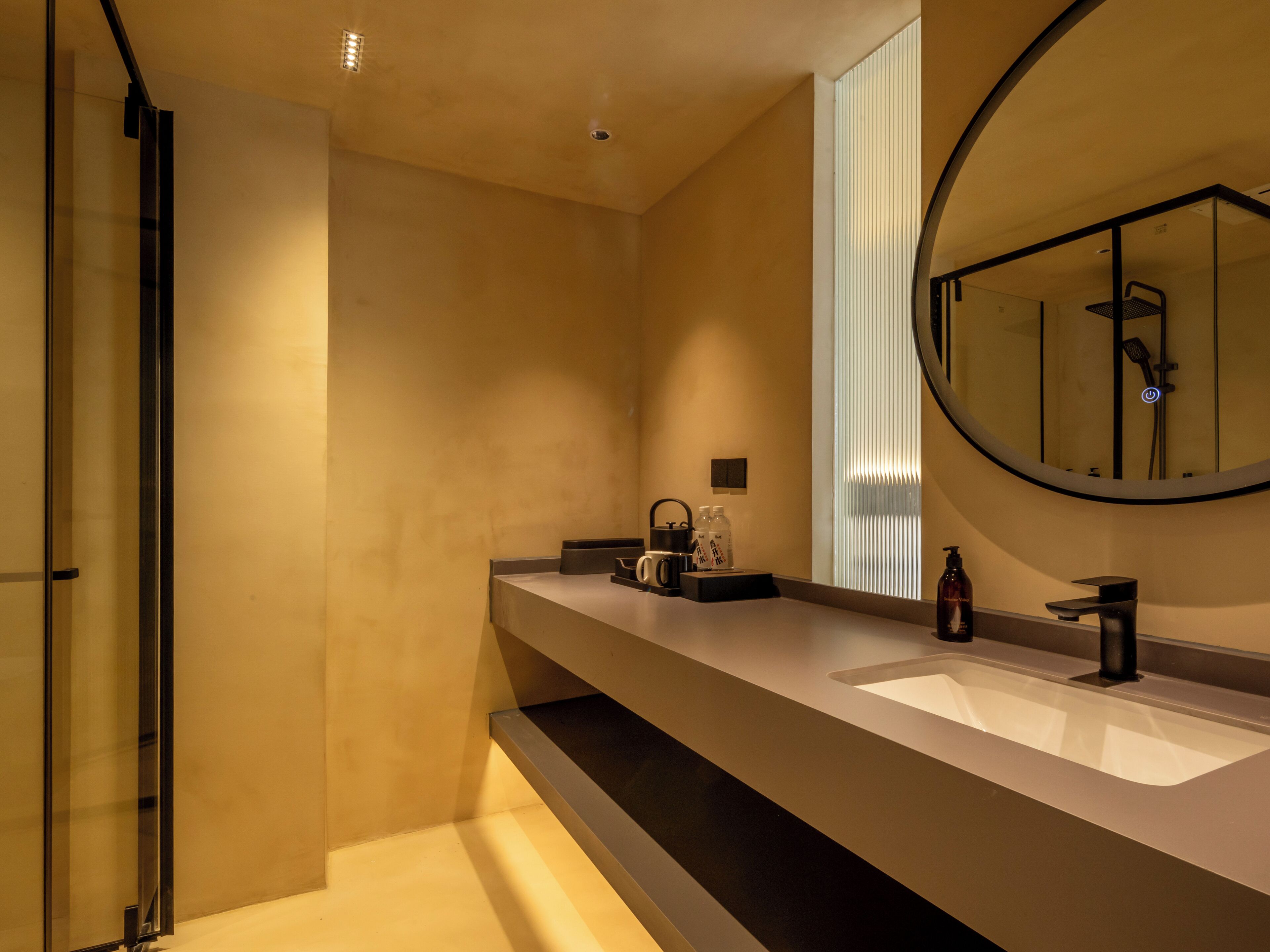 Un baño moderno con un espejo grande, una ducha y un tocador con lavabo.