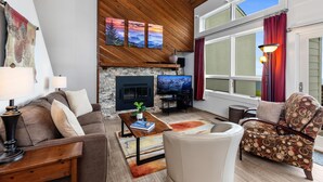 A cozy living room with a fireplace, a television, and comfortable seating.