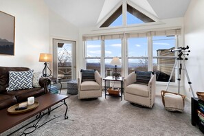 A cozy living room with a brown leather couch, two beige armchairs, a coffee table, and a telescope on a tripod. - Shenandoah Ridge 27 with Wintergreen Advantage (Wintergreen)