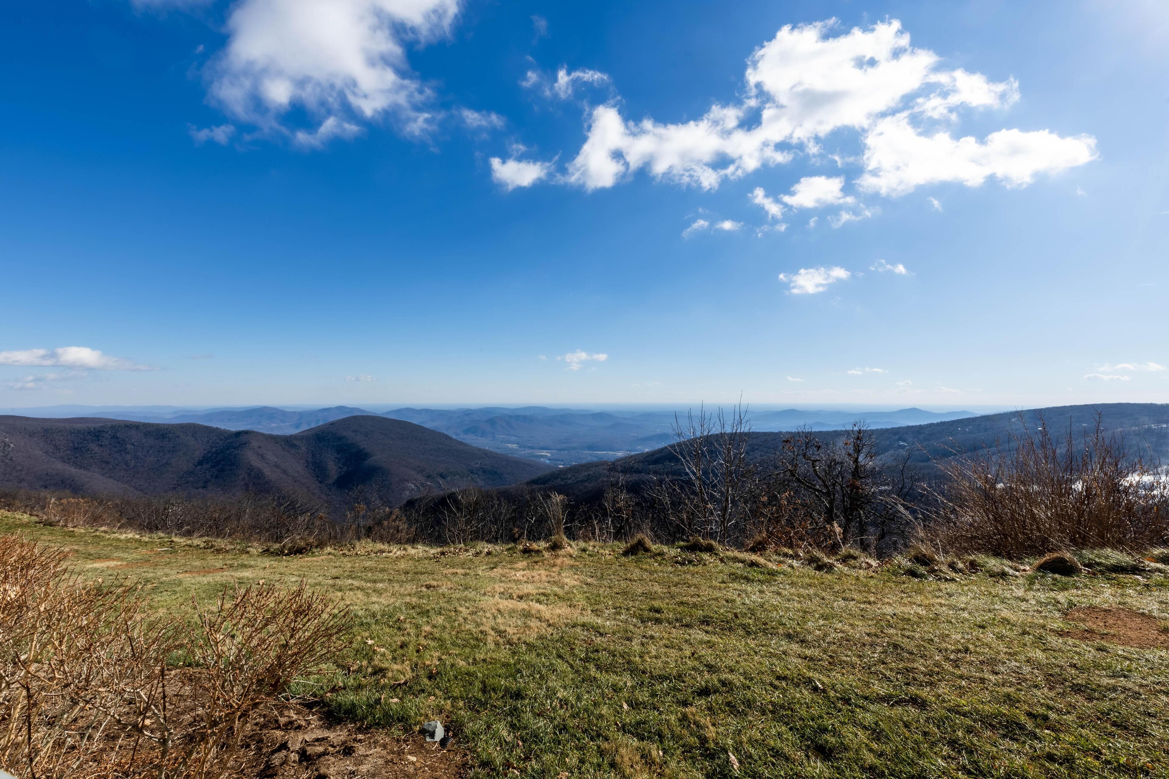 Ein weiter Panoramablick auf eine gebirgige Landschaft bei klarem Himmel.