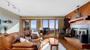 A modern living room with a leather sofa, a wooden coffee table, and a fireplace.