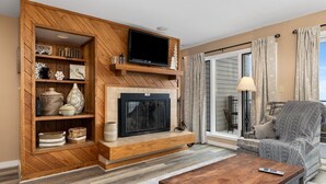 Un salón con chimenea, televisión y un área de descanso confortable.