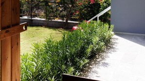 Un balcón con vistas a un jardín y al paisaje urbano.