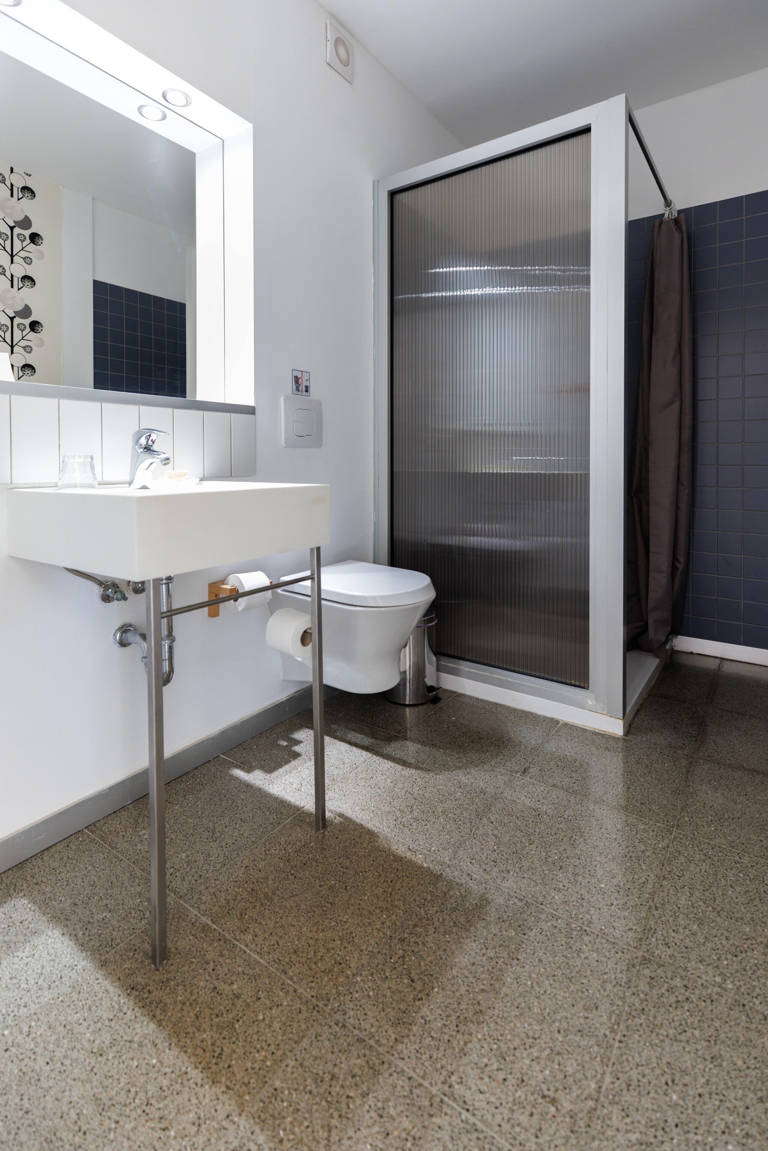 Een badkamer met een witte wastafel, toilet en douchecabine.