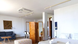 Ein modernes Hotelzimmer mit Bett, einer Couch, einer Holzwand und einem Gemälde an der Wand.