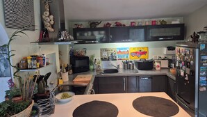 A modern kitchen with a central island, microwave, toaster, and refrigerator. - Your stay in the Alps between lakes and mountains. (Saint-Théoffrey)