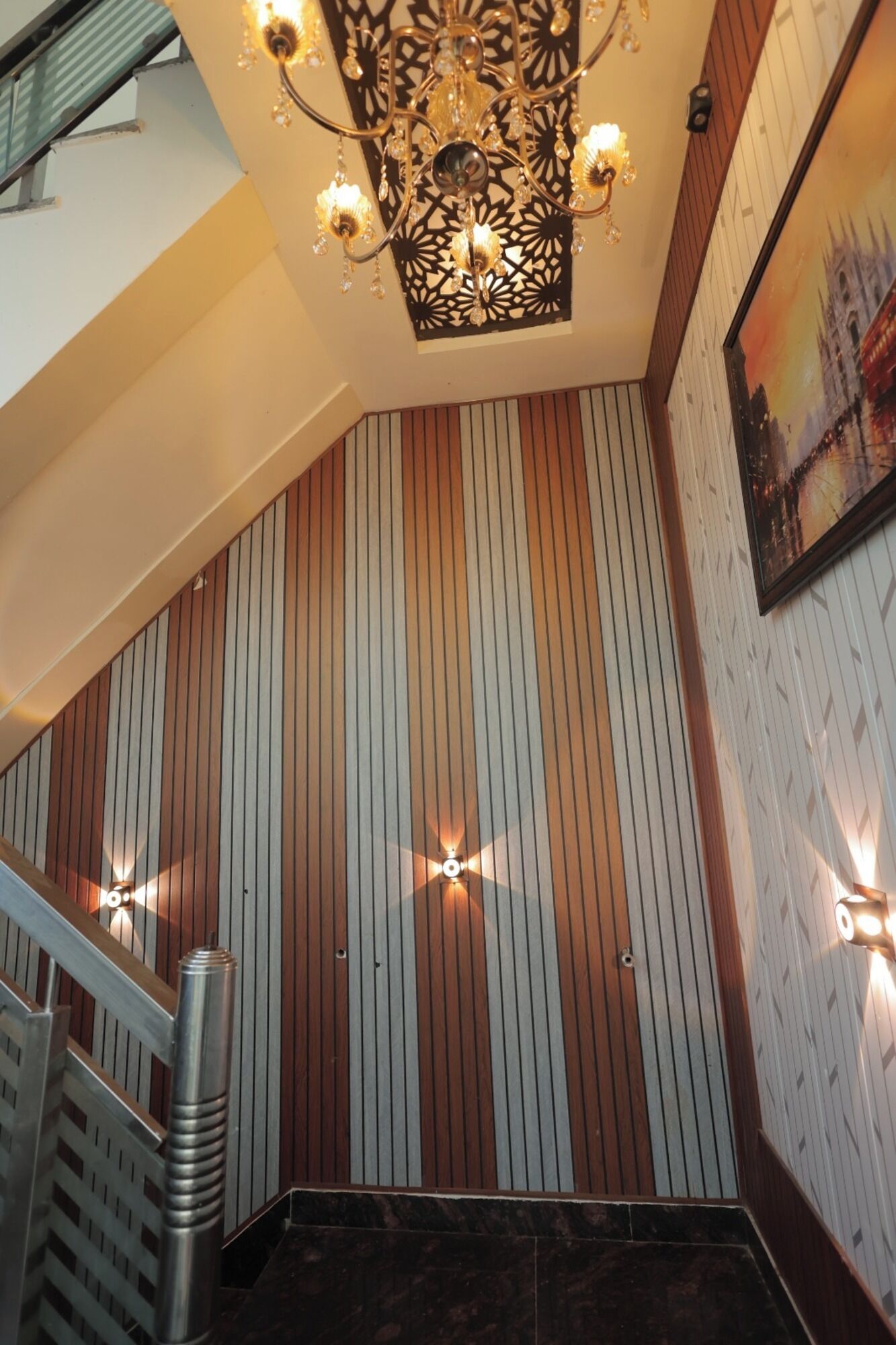 A staircase with striped wall panels and a decorative ceiling light fixture.