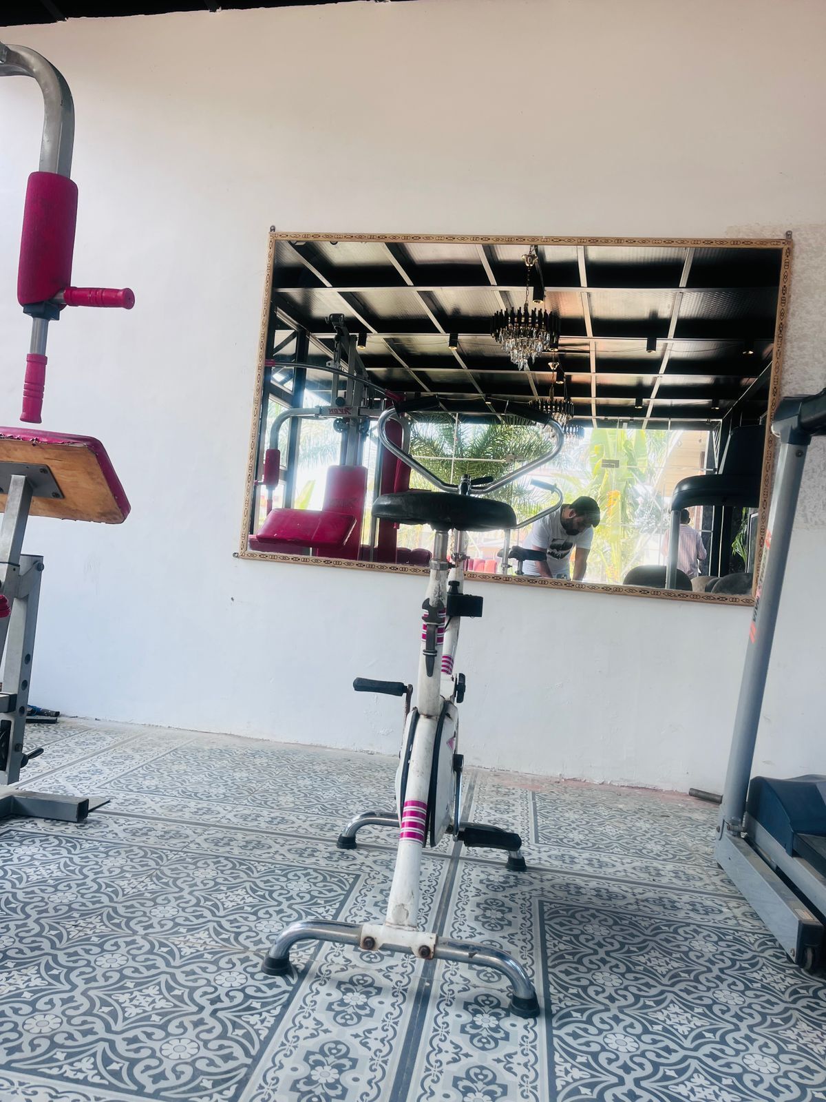 A gym with exercise equipment, including a stationary bike and a red exercise machine.