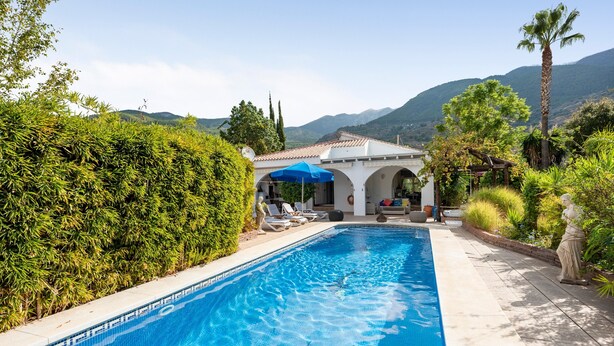 A swimming pool with lounge chairs, a pergola with a blue umbrella, and a statue. - Holiday Home 'Villa Eden' with Mountain View, Wi-Fi and Air Conditioning (Alcaucín)