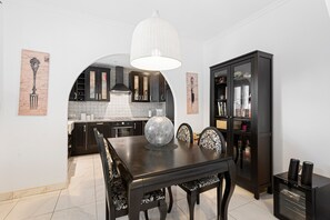 A dining area with a table, chairs, a vase, a cabinet, and a hanging light fixture. - Holiday Home 'Villa Eden' with Mountain View, Wi-Fi and Air Conditioning (Alcaucín)