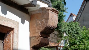 A close-up of a building's corner with a decorative stone column and a white wall. - L'Ecrevisse (Wissembourg)