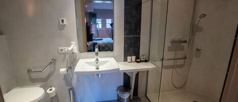 Un baño moderno con inodoro, lavabo y ducha.