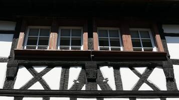 A half-timbered building with two windows and a balcony.