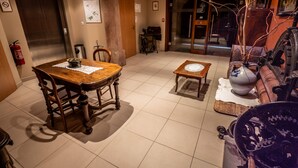 A spacious room with a wooden dining table, a sofa, and a vintage sewing machine. - L'Ecrevisse (Wissembourg)